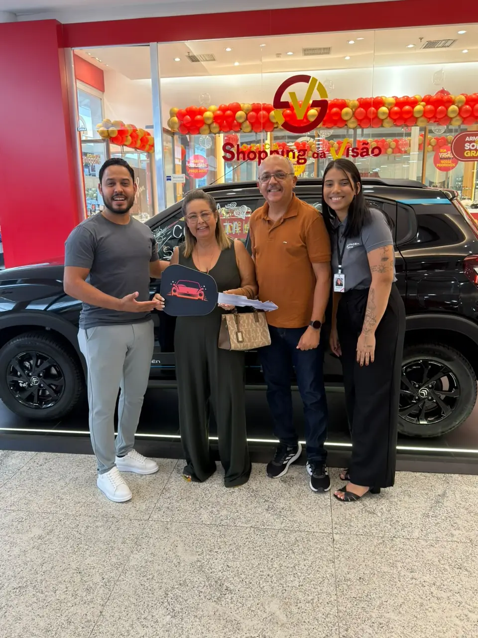 Consultores da ABA com um casal de clientes segurando a chave cenográfica em frente a um Citroën preto
