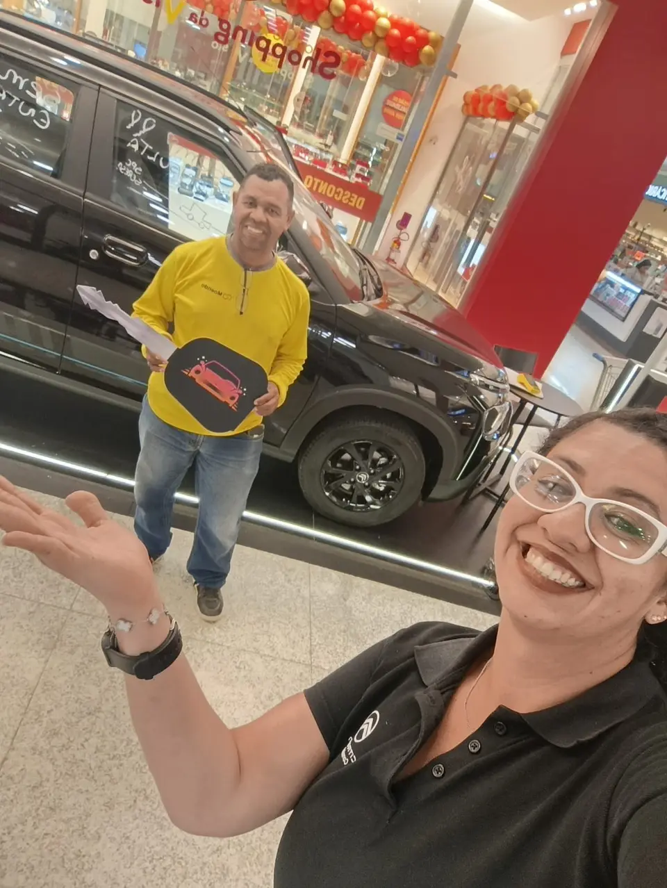 Consultora da ABA em selfie com cliente segurando a chave em frente a um Citroën