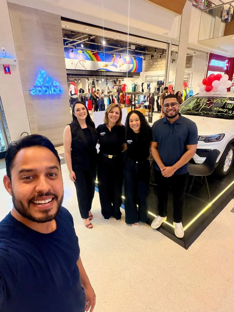 Equipe da ABA reunida no stand do shopping, com o carro em exposição