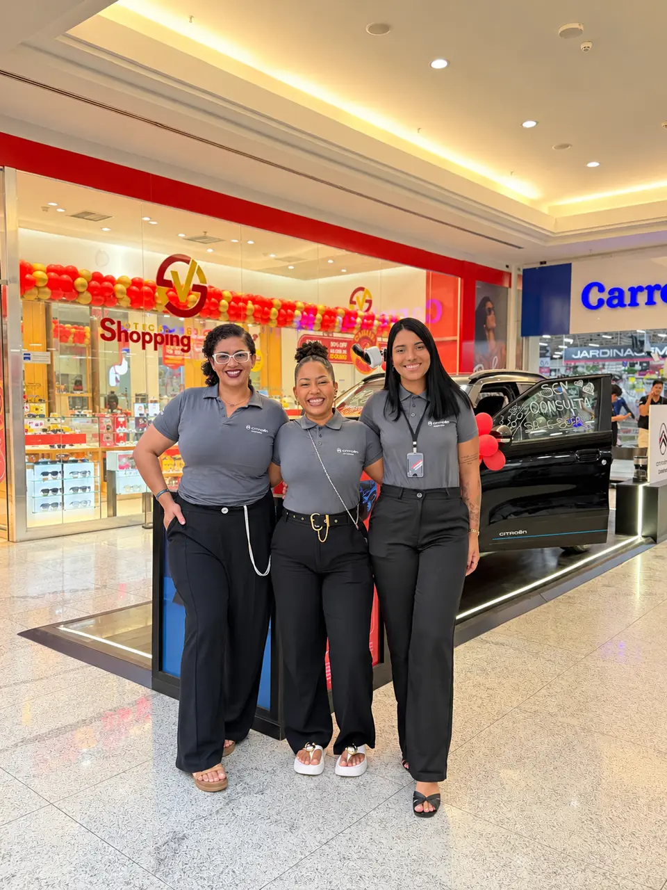 Três consultoras da ABA com uniforme Citroën em frente ao stand no Shopping Guararapes